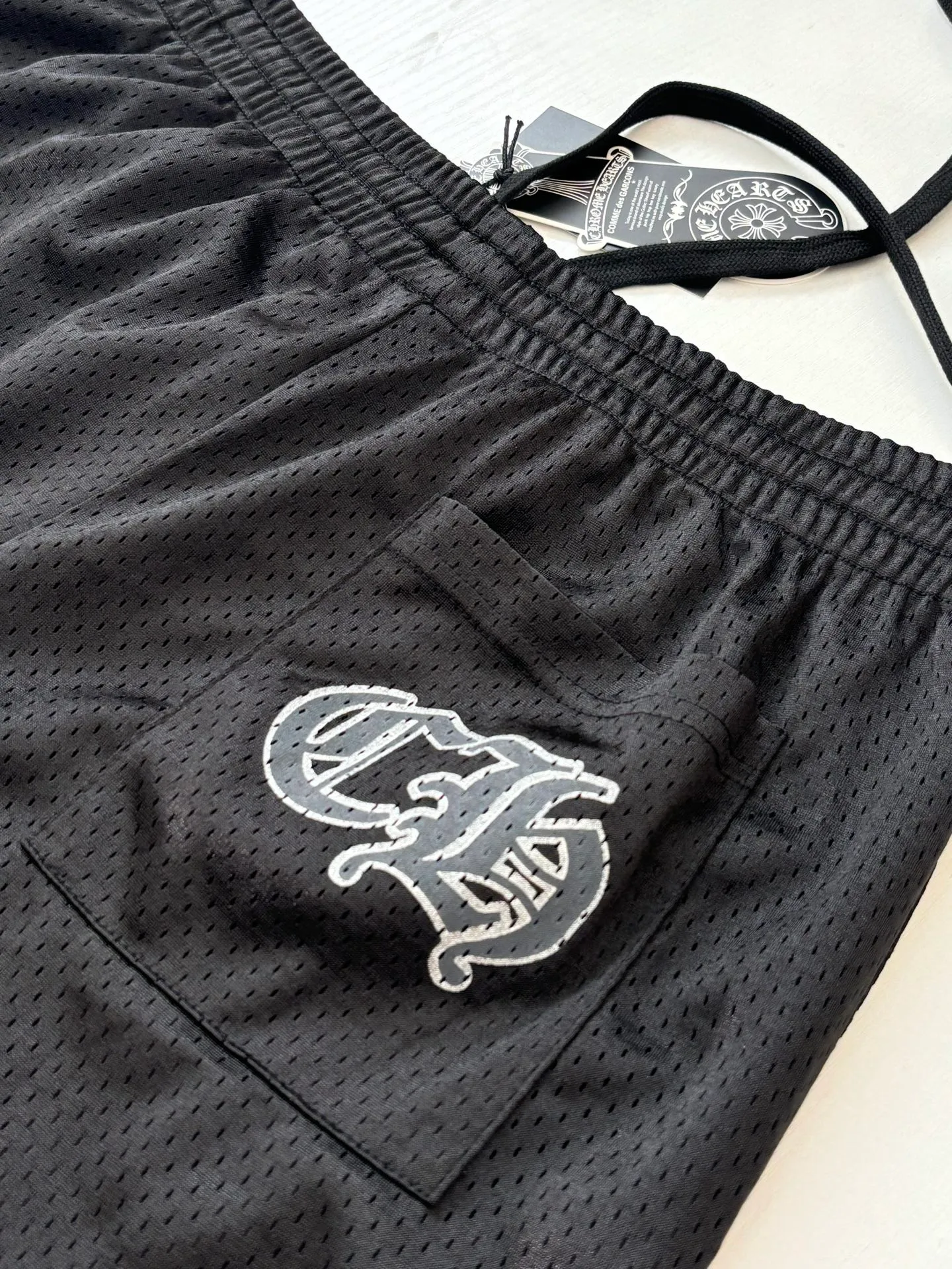 P340 Chrome Heart*/Chrome Heart Sanskrit mesh ice hockey suit straight trousers. The original version was purchased for 15,989 and developed. The fabric is made of custom weaving and dyeing technology. It is made of selected black mesh fabric, showing a unique sports style. The fabric has been specially treated to provide excellent breathability and comfort while maintaining a crisp and structured look. The double-layer design structure enhances the overall texture and makes the wearing experience more three-dimensional and full. The brand's iconic patterns are printed in many places, and high-precision printing technology is used to ensure that the patterns are clear and sharp. The silver printing has a glitter effect, showing charming luster changes under different lights. All printings undergo strict color difference control to ensure accurate color reproduction. The silver-plated pattern design on the sleeve arms is particularly eye-catching, showing the brand's consistent dark luxury style. In terms of details, the latest custom-woven labels are used, and the workmanship is exquisite. The overall shape is designed for both men and women, with both fashion and practicality. This T-shirt perfectly combines sports elements with high fashion craftsmanship, making it the brand's iconic street style item.  Size：S/M/L